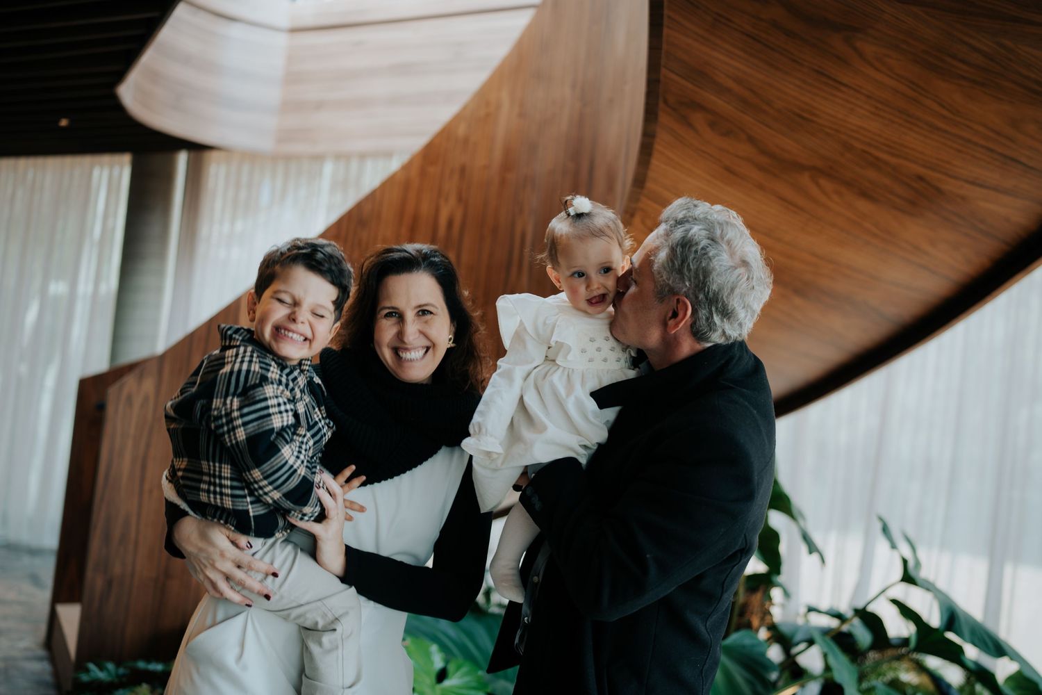 Multi-generational family gathering indoors sharing joyful moments together.