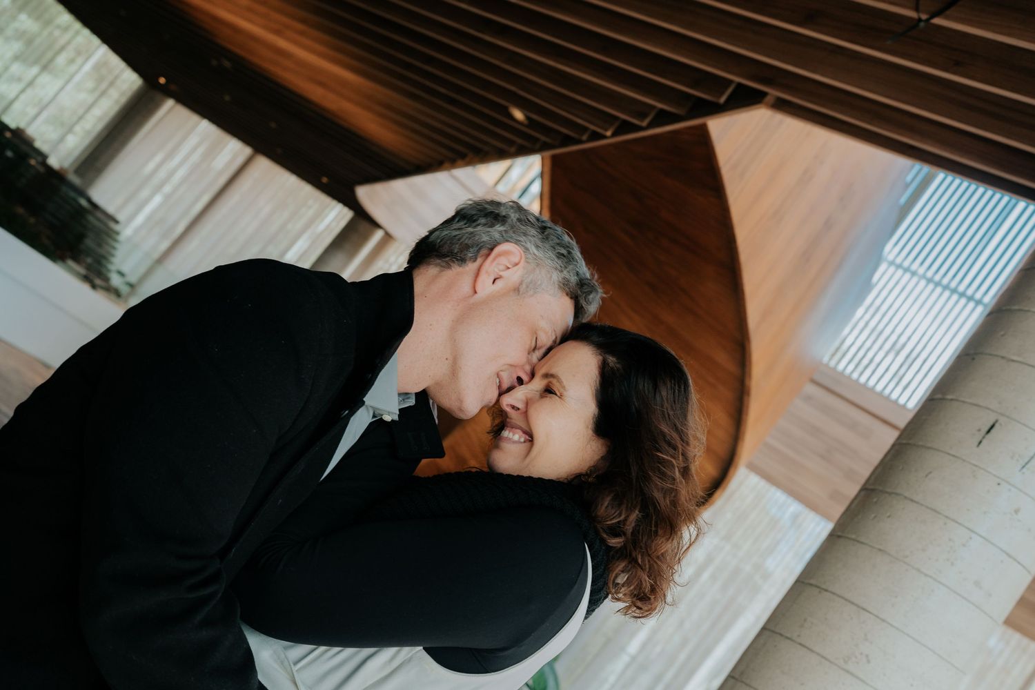 Intimate indoor portrait of couple sharing affectionate moment.