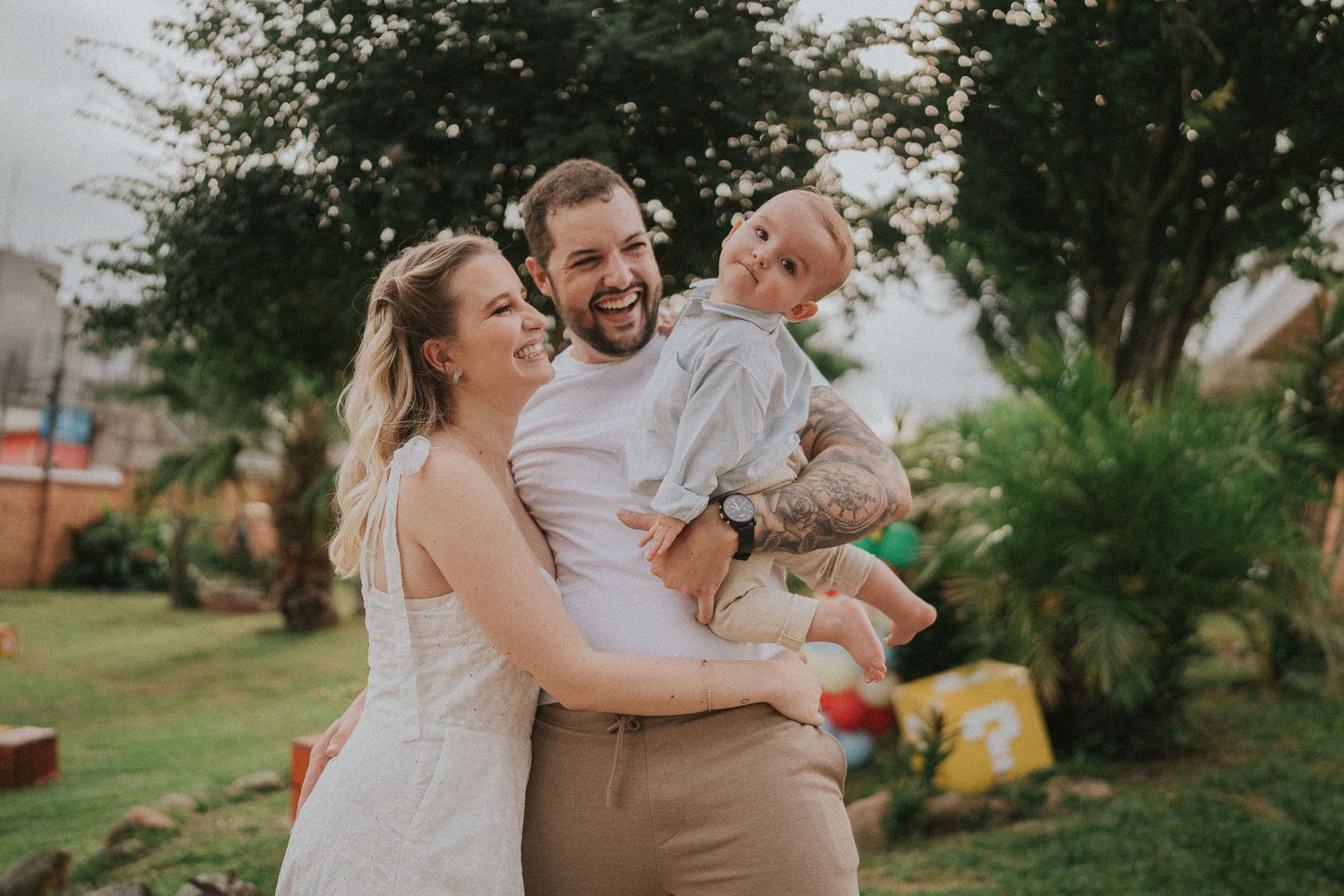 Candid outdoor celebration photo capturing laughter and joy between three people.