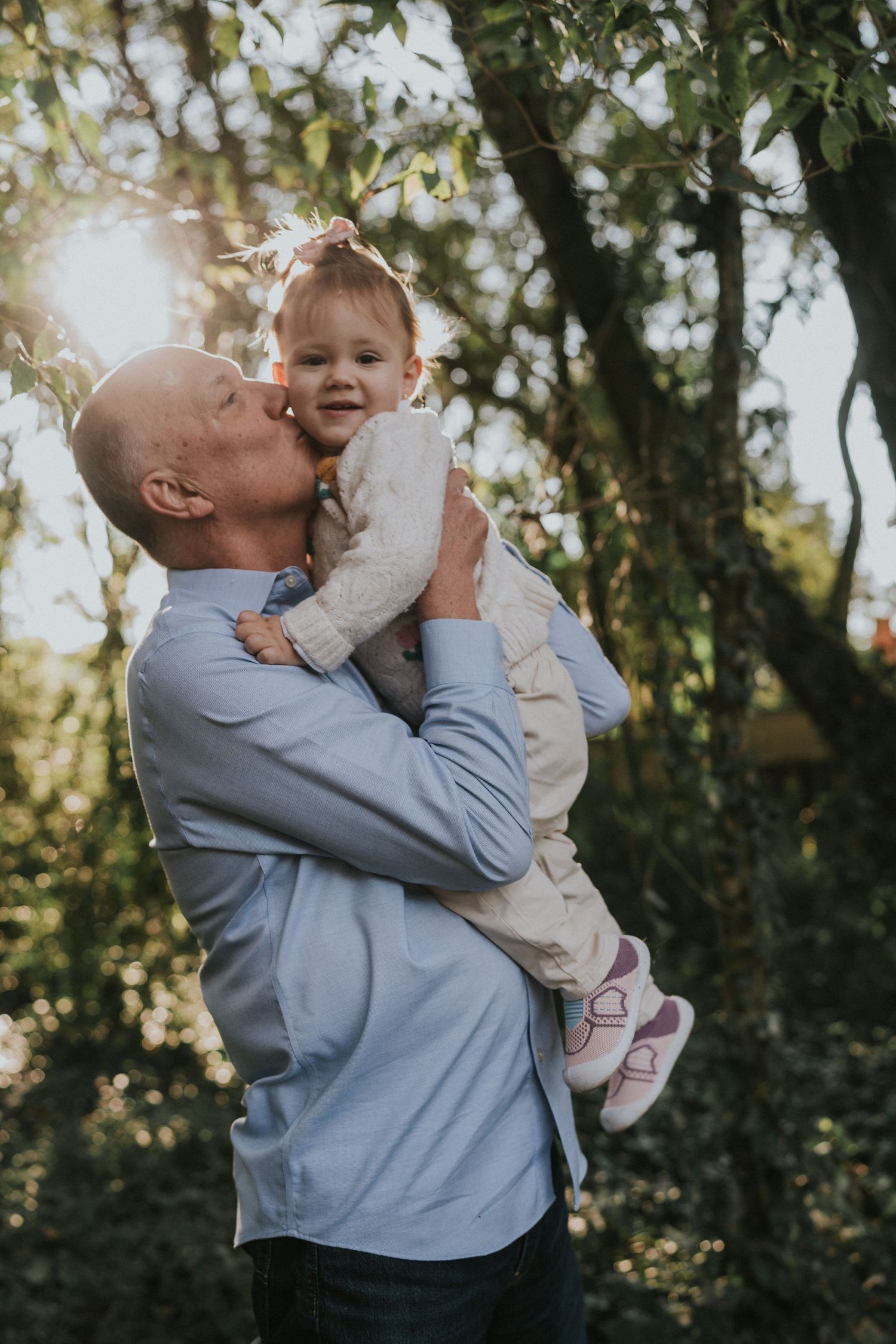 Sweet outdoor portrait showing affectionate moment between caregiver and young child.