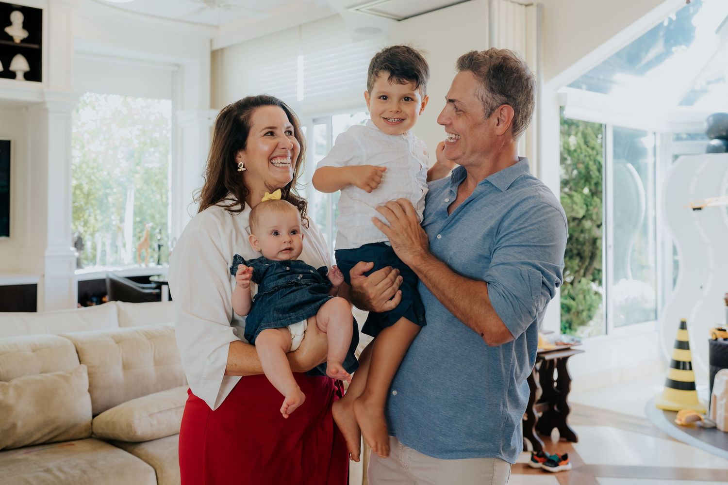 Happy family moment in bright living room with children and parents.