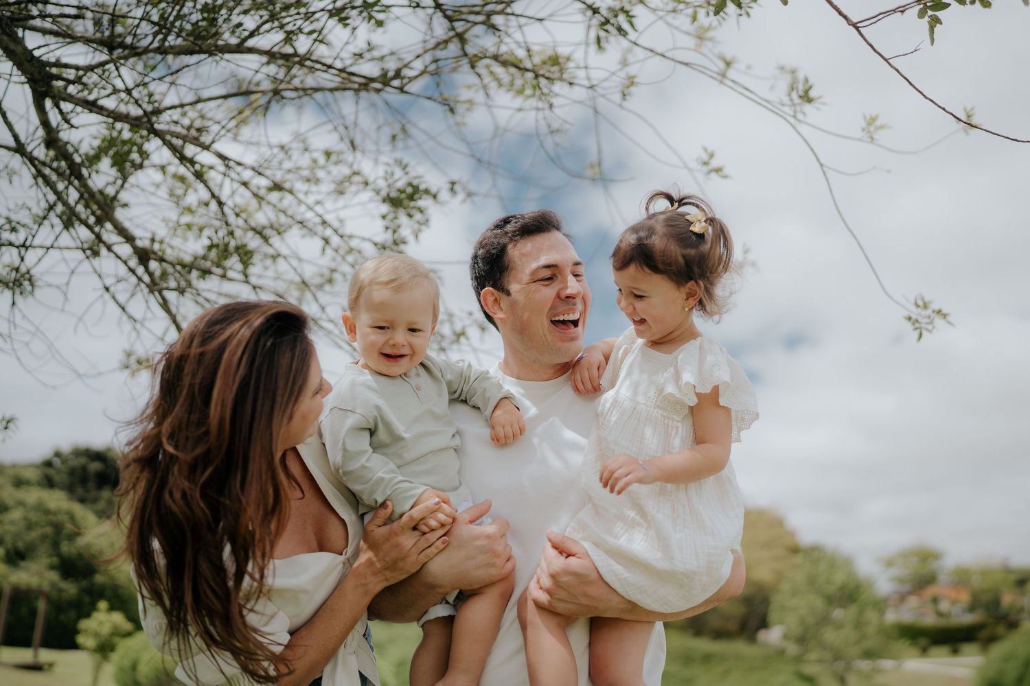 Joyful family moments captured during outdoor photo session under cloudy skies.