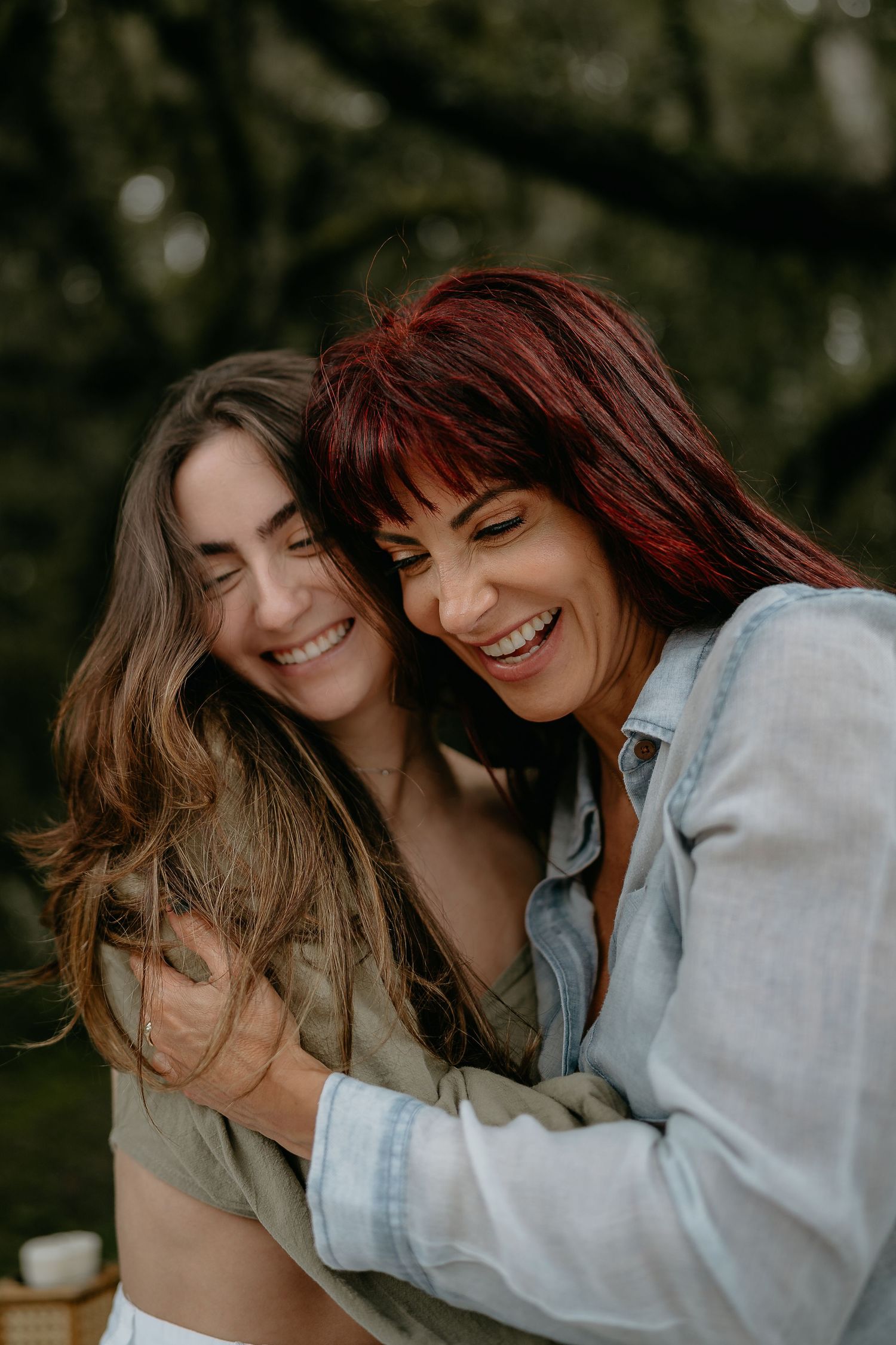 Two friends sharing a joyful intimate moment while wearing light colored shirts.