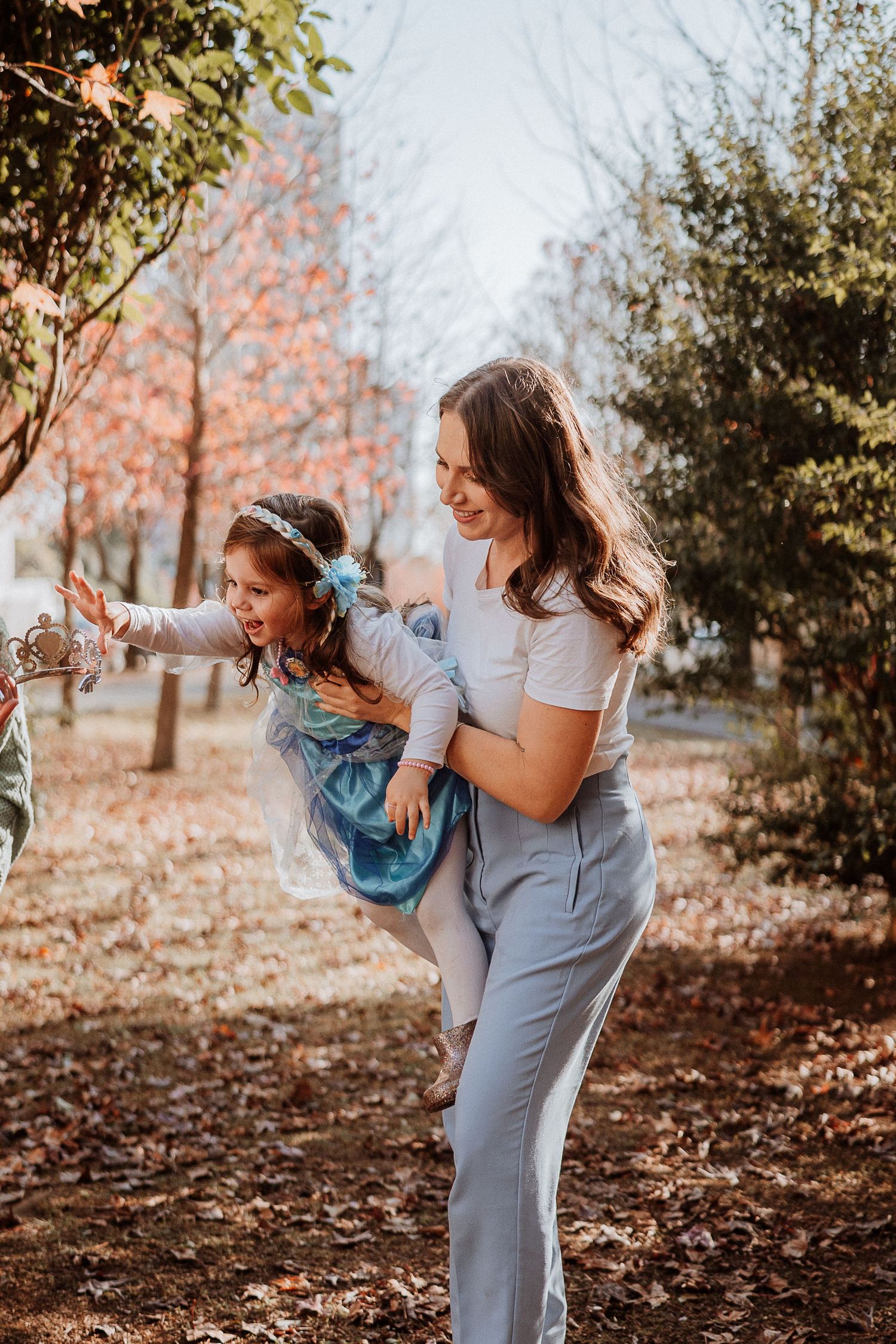 Playful moment between two people in casual attire during autumn.
