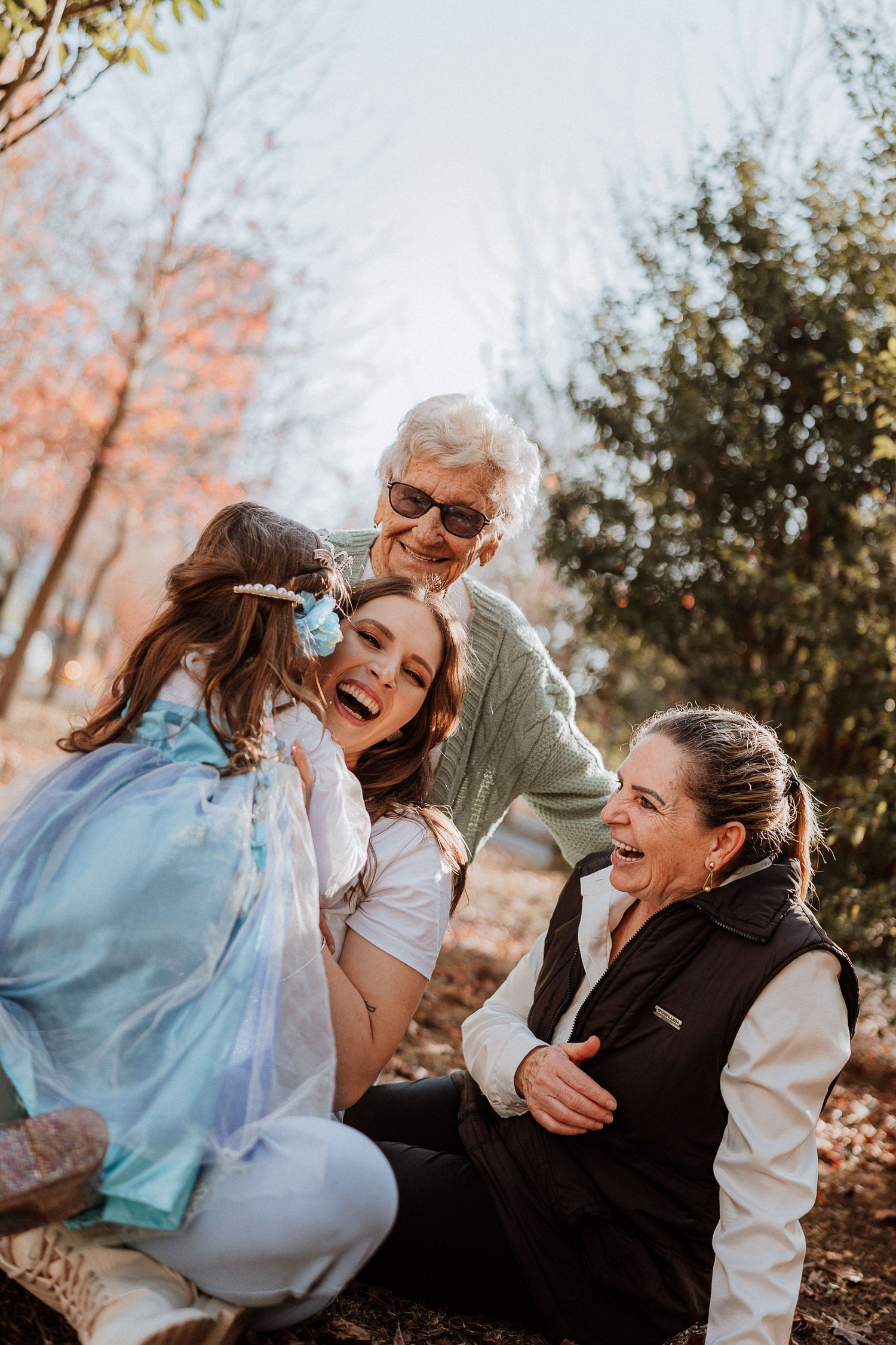 Family sharing laughter and hugs during outdoor autumn photoshoot.