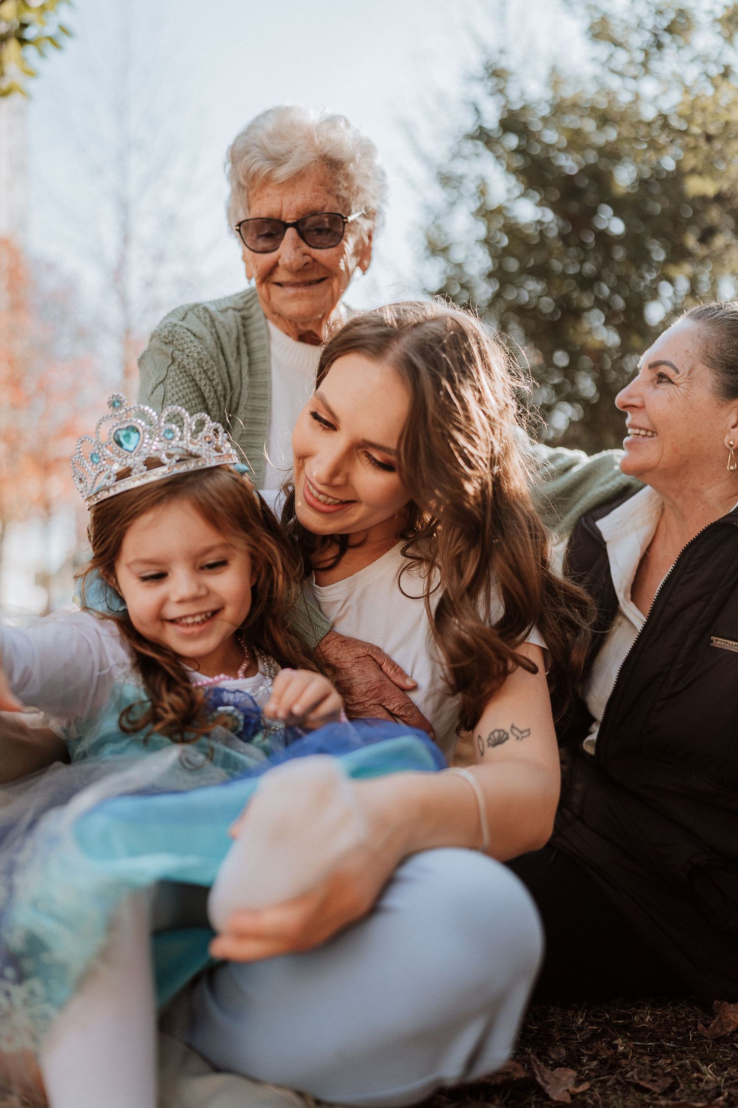 Multi-generational family group sharing joyful moment outdoors in fall setting.