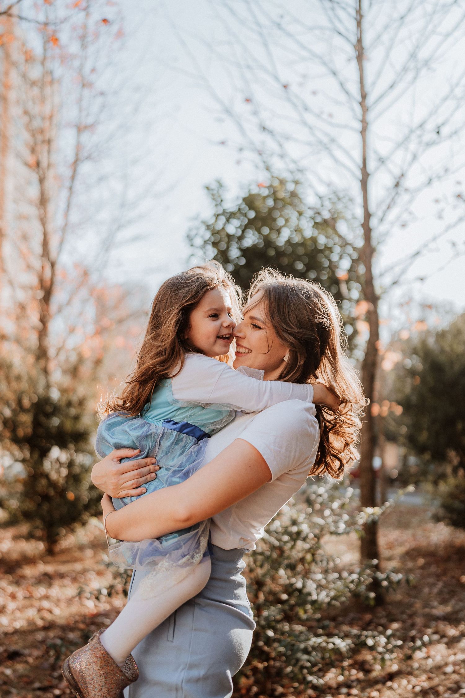 Joyful mother and child embracing outdoors in autumn setting.