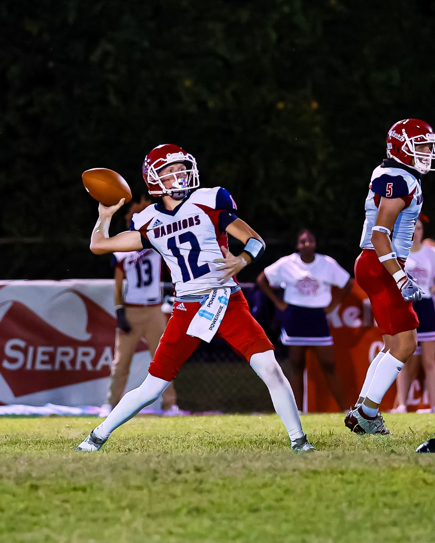 Football player dives through the air to catch a pass during a game.