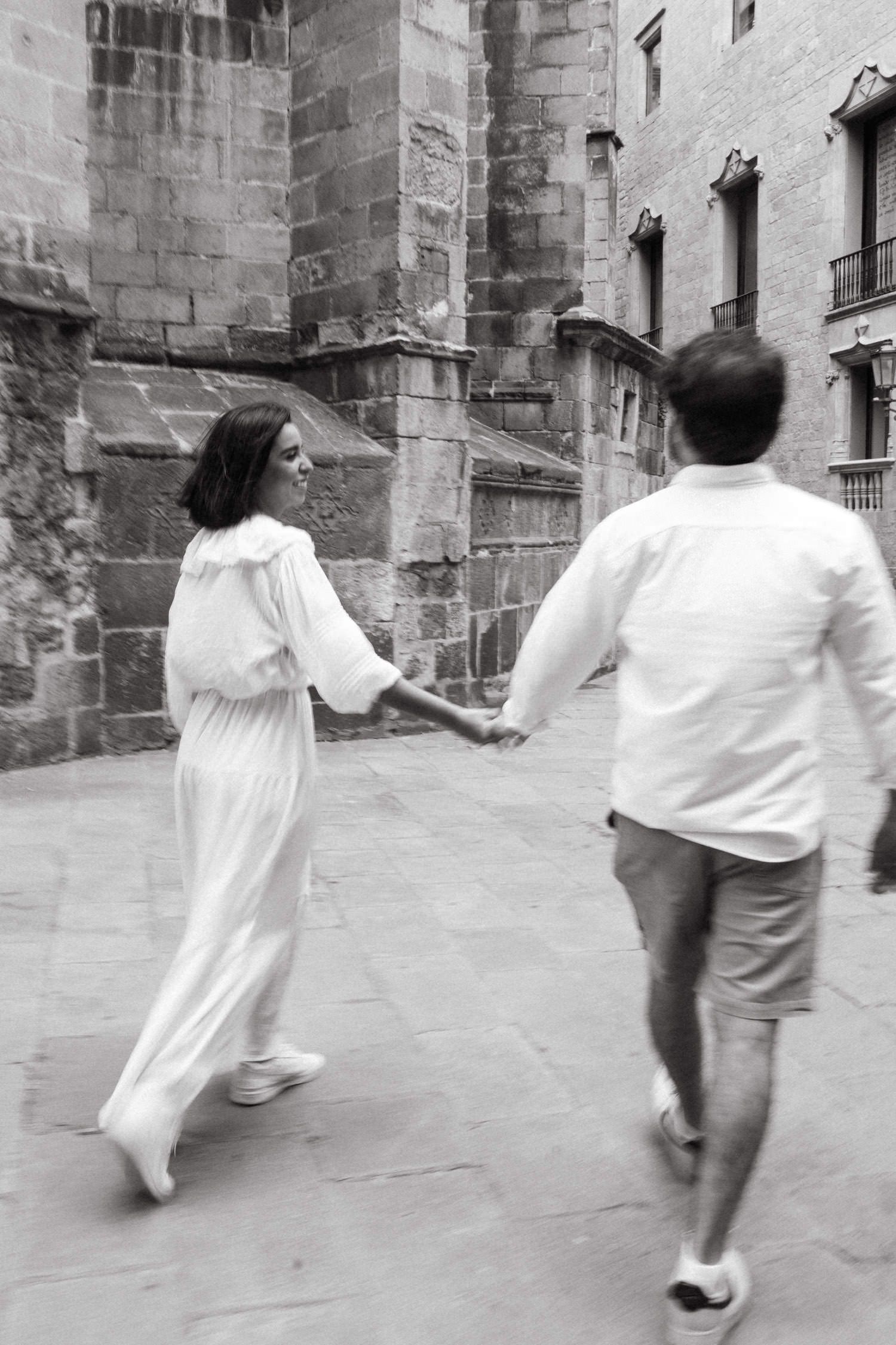 Black and white photos capture a couple running playfully through historic stone streets.
