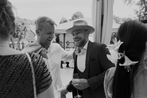 Guests engaged in animated conversation during an outdoor wedding reception.