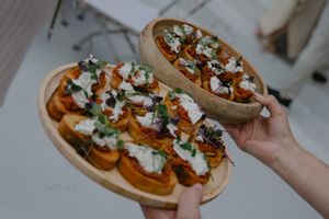 Artisanal bruschetta topped with goat cheese and herbs served on wooden boards.