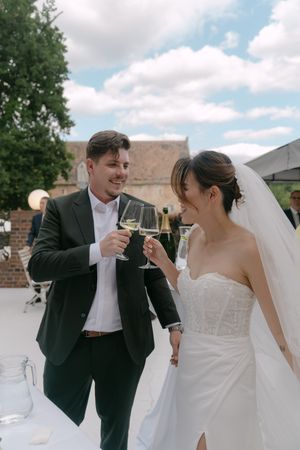 Newlyweds share playful moment during outdoor wedding photoshoot.