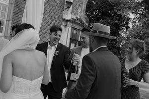 Wedding party gathers outside brick venue during celebration.