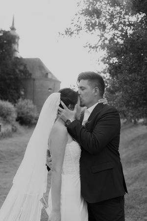 Black and white portrait of romantic wedding moment in garden setting.
