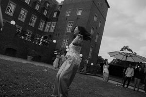 Black and white photo of a wedding celebration outside a brick building.