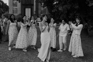 Wedding guests dancing and celebrating outdoors on a sunny day.