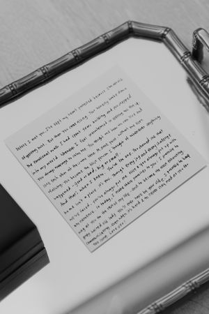 Handwritten text on white paper with pen visible in frame.