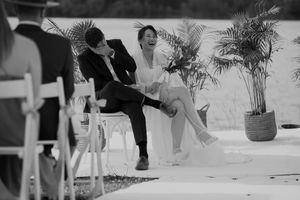 Black and white photo of a wedding ceremony with decorative palm fronds.