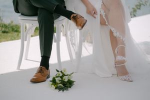 Close-up detail of wedding attire and footwear during an outdoor ceremony.