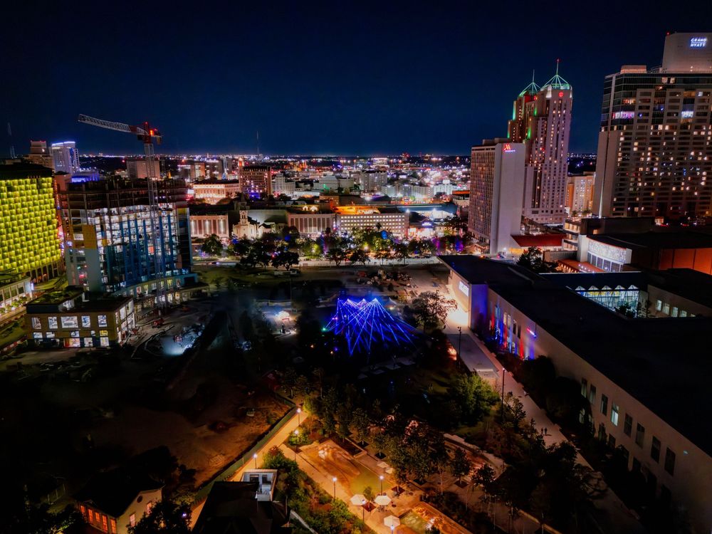 Nighttime cityscape showing illuminated buildings and urban development.