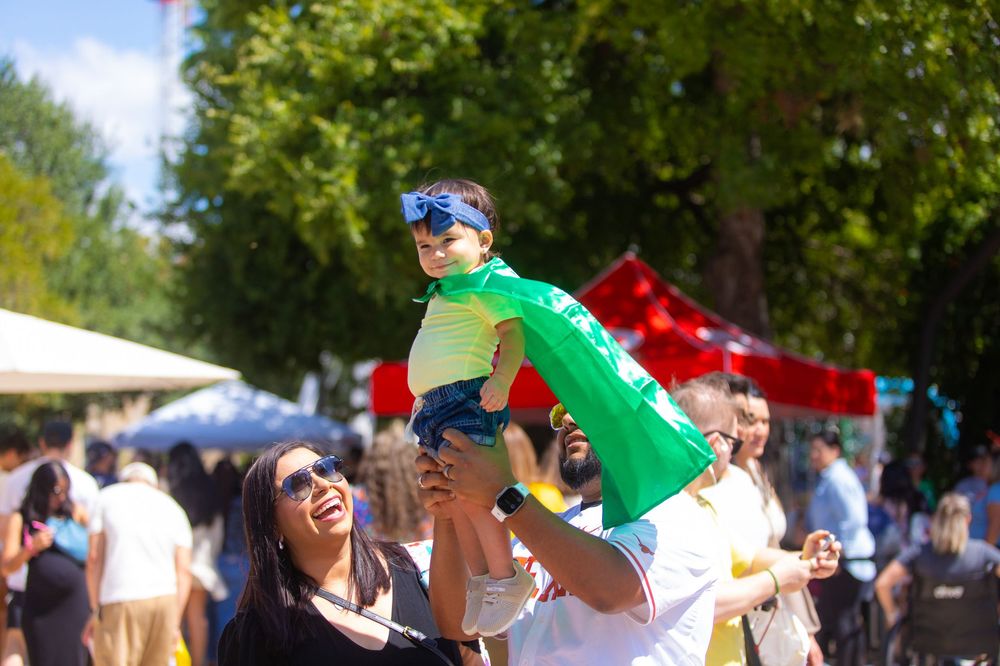 Festival attendees enjoying outdoor celebration on sunny day.