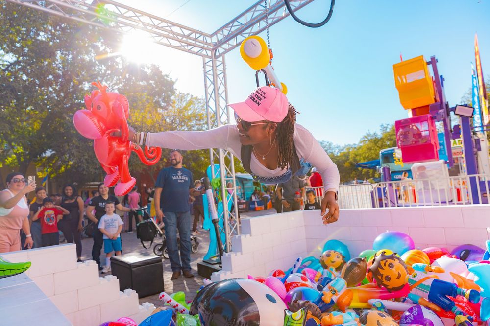 Outdoor festival setup with colorful decorations and vendor booths under bright sunlight.