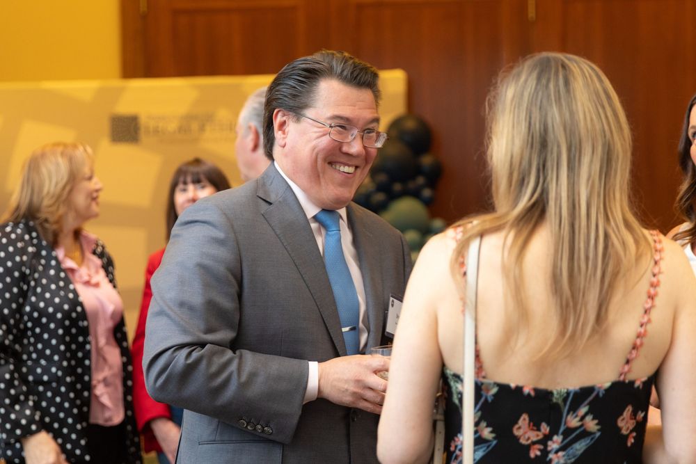 Professional networking event in an elegant indoor venue with warm lighting.