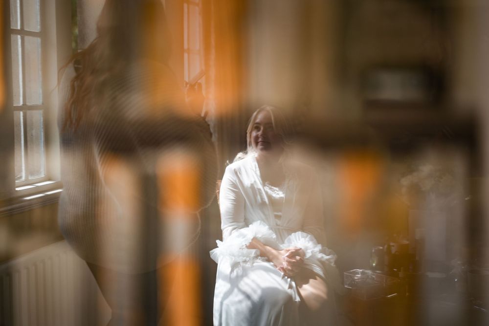 Ethereal bridal portraits with soft focus and warm lighting through window.