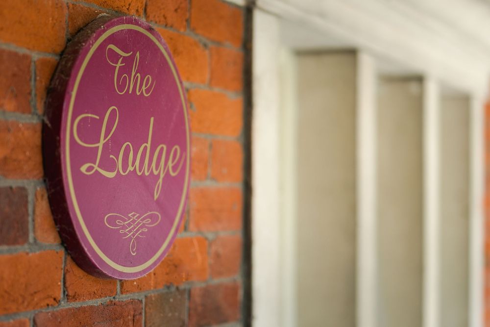Pink and gold lodge signage mounted on exposed brick wall interior.