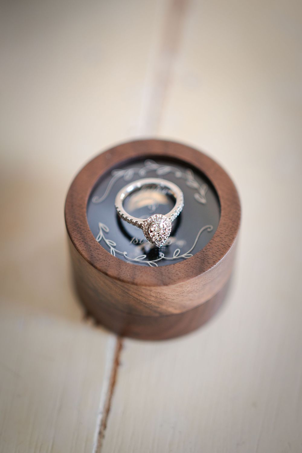 Close-up sequence of an elegant diamond engagement ring nestled in a wooden ring box.