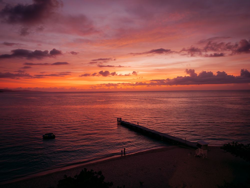 A series of sunset photos over the ocean featuring dark silhouettes of docks and coastline against vibrant orange skies.