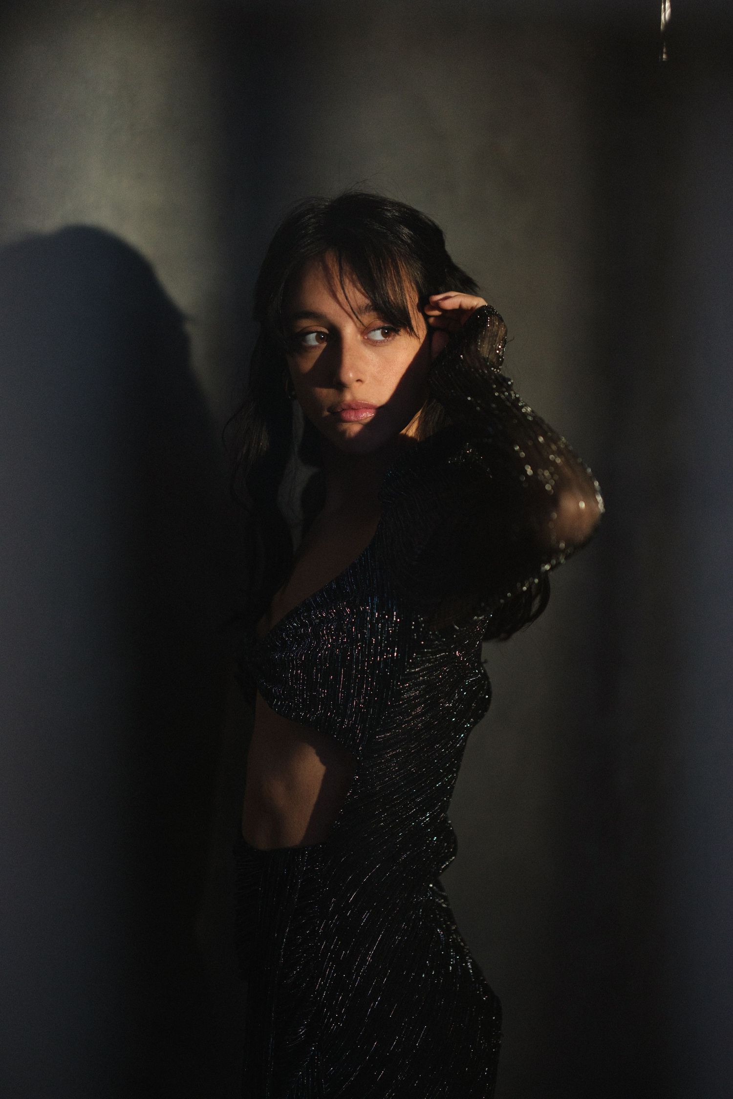 Dramatic portrait sequence featuring a figure in a sparkly dark outfit against shadowy background.