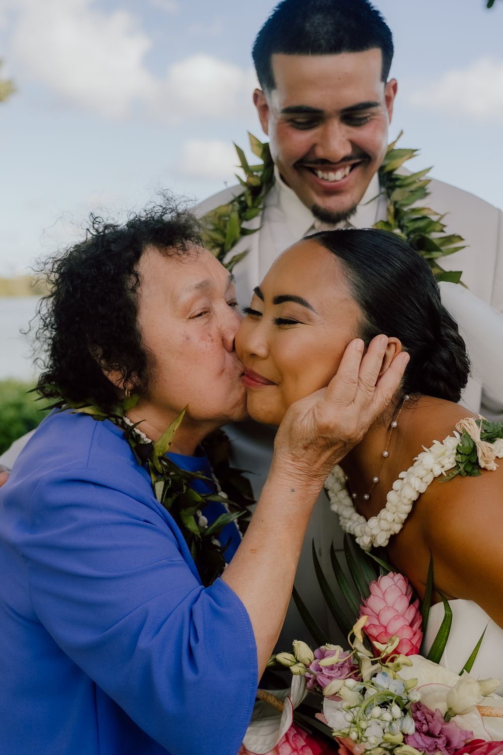 A tender moment shared between family members during an outdoor wedding celebration.