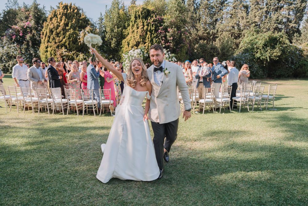 Newlyweds walking back down the aisle during their outdoor garden wedding ceremony.