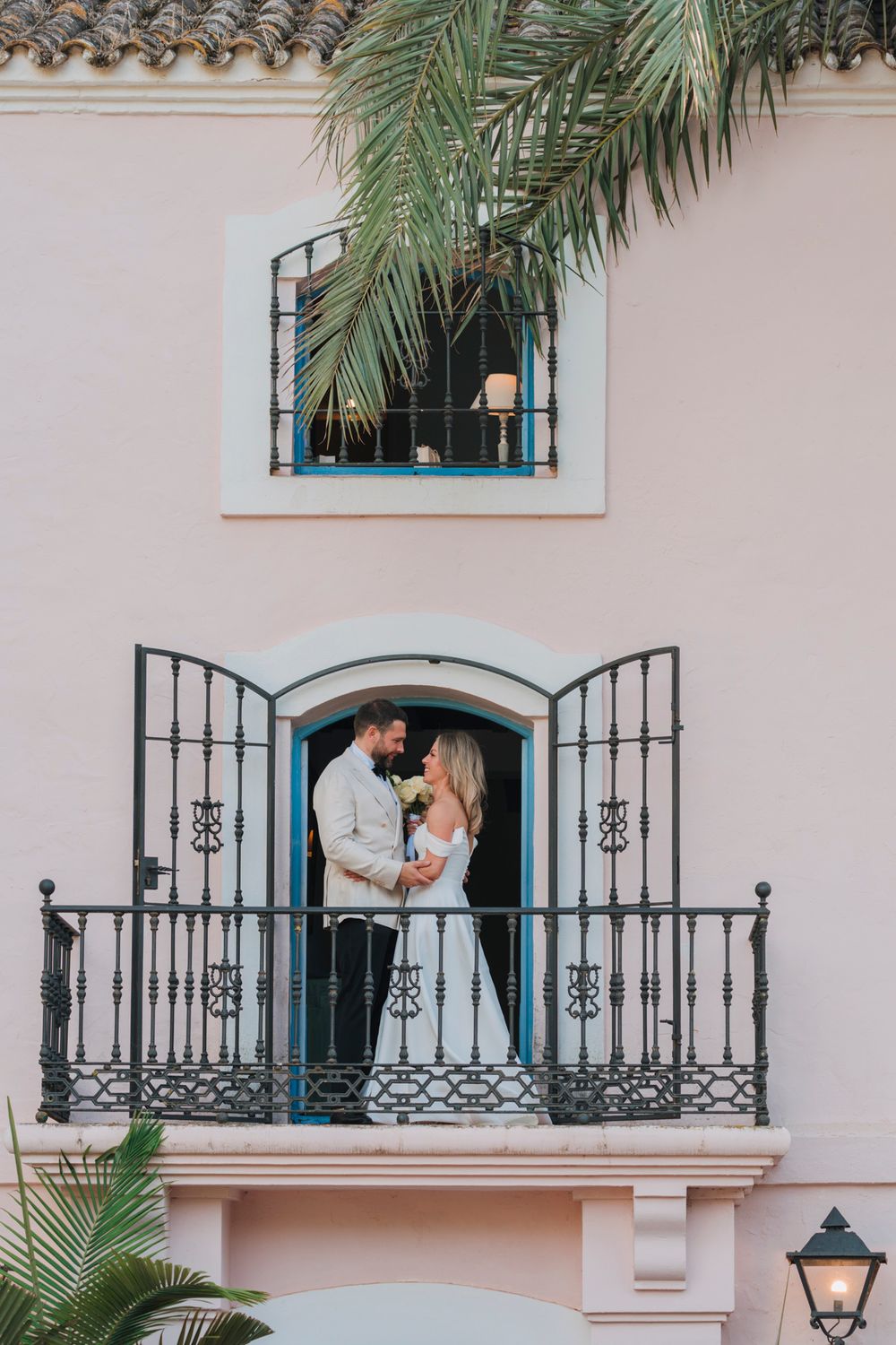 Romantic moment on a Mediterranean villa balcony with wrought iron details.