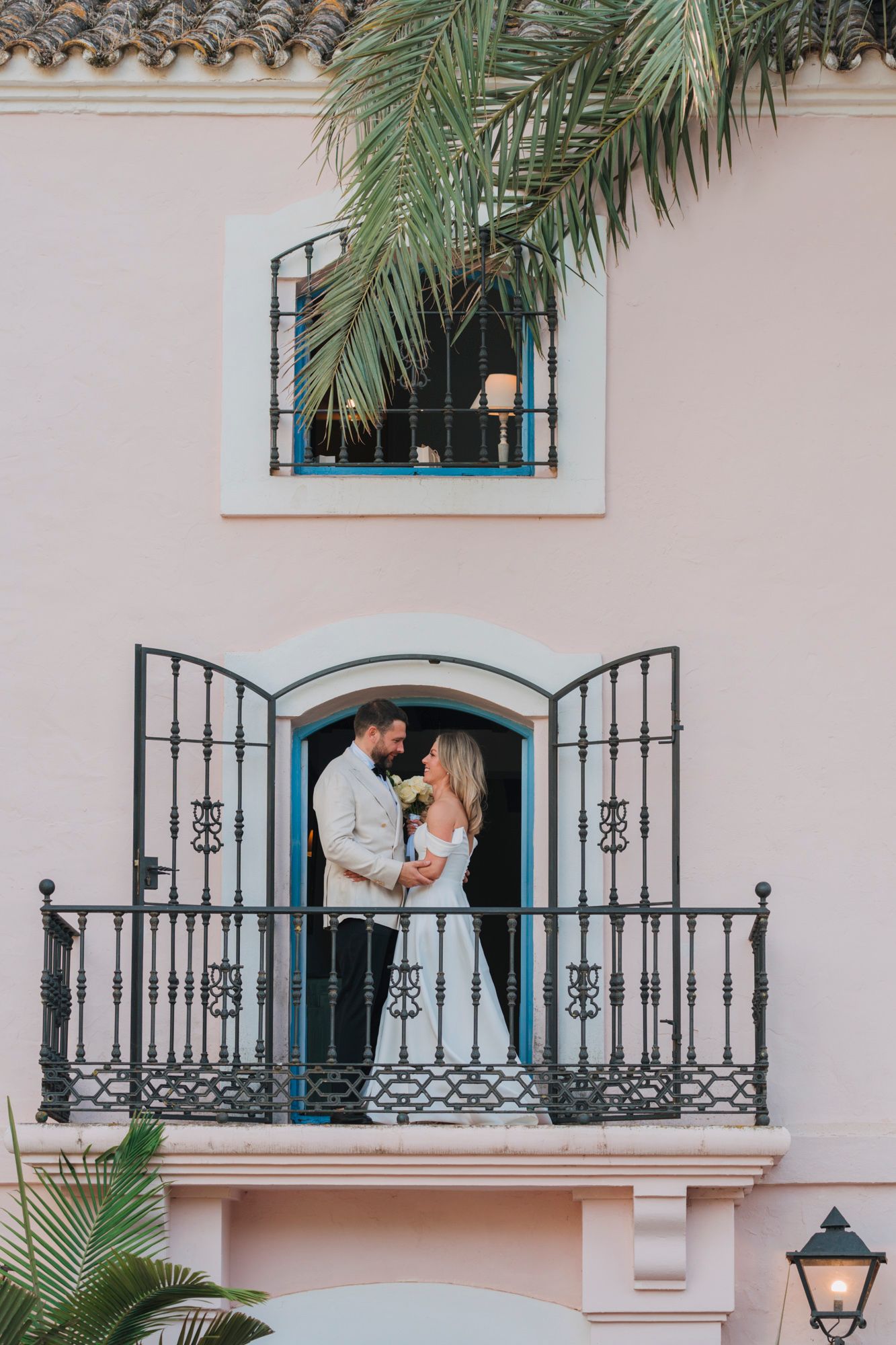 Romantic moment on a Mediterranean villa balcony with wrought iron details.