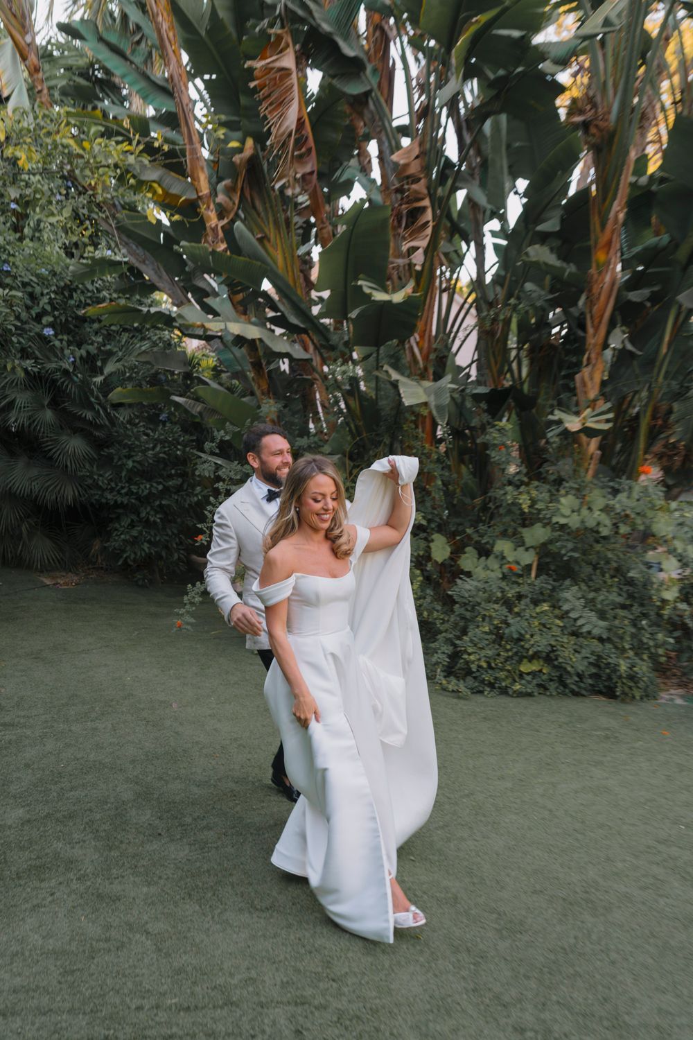 Celebratory moment captured between newlyweds in a lush garden setting.