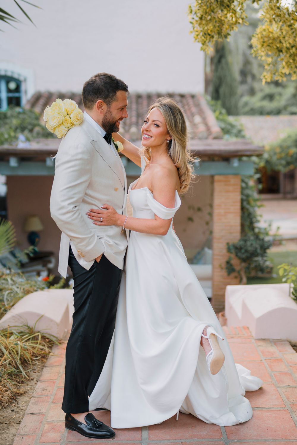 A playful moment between newlyweds as they dance together in their wedding attire.