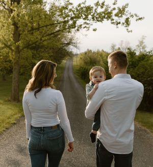 A family walking together on a country road during golden hour sunset.
