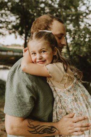 Intimate outdoor portrait of joyful embrace against natural background.