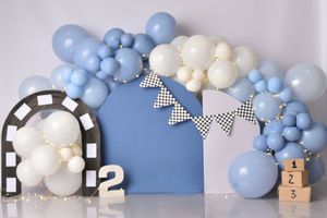 Blue and white balloon arch installation with checkered bow accents creates an elegant party backdrop.