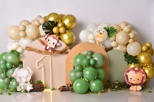 Elegant safari themed first birthday party decoration with gold and green balloons, jungle animals, and number one decor.