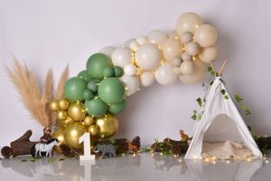 Neutral toned balloon garland with pampas grass and white decorative elements against a minimalist wall display.