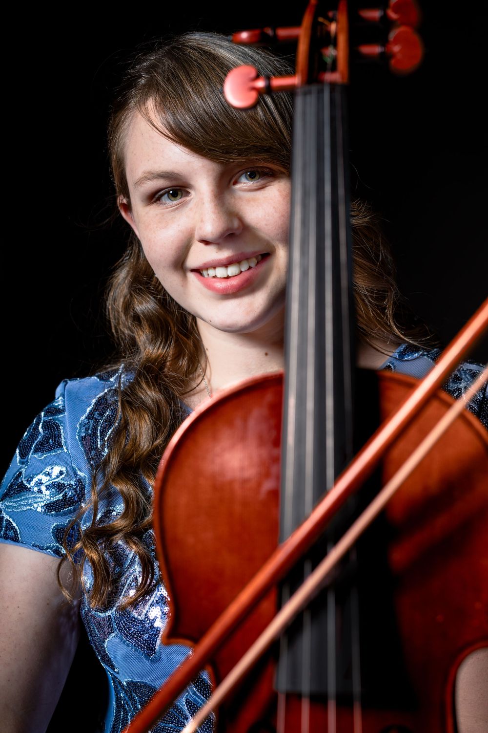Close-up view of violin strings and bridge during musical performance.