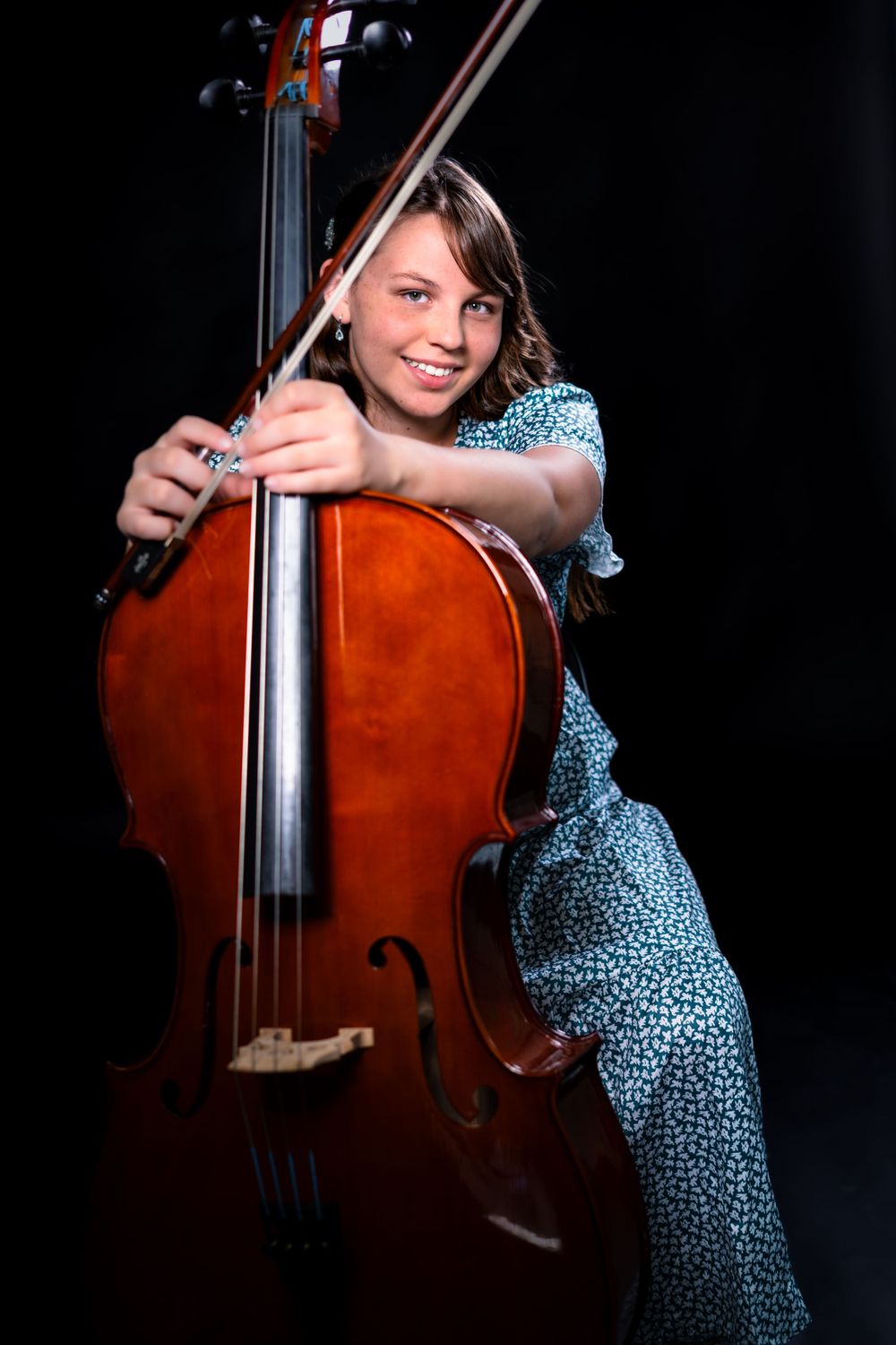 Artistic sequence showing musician playing cello in spotted dress.