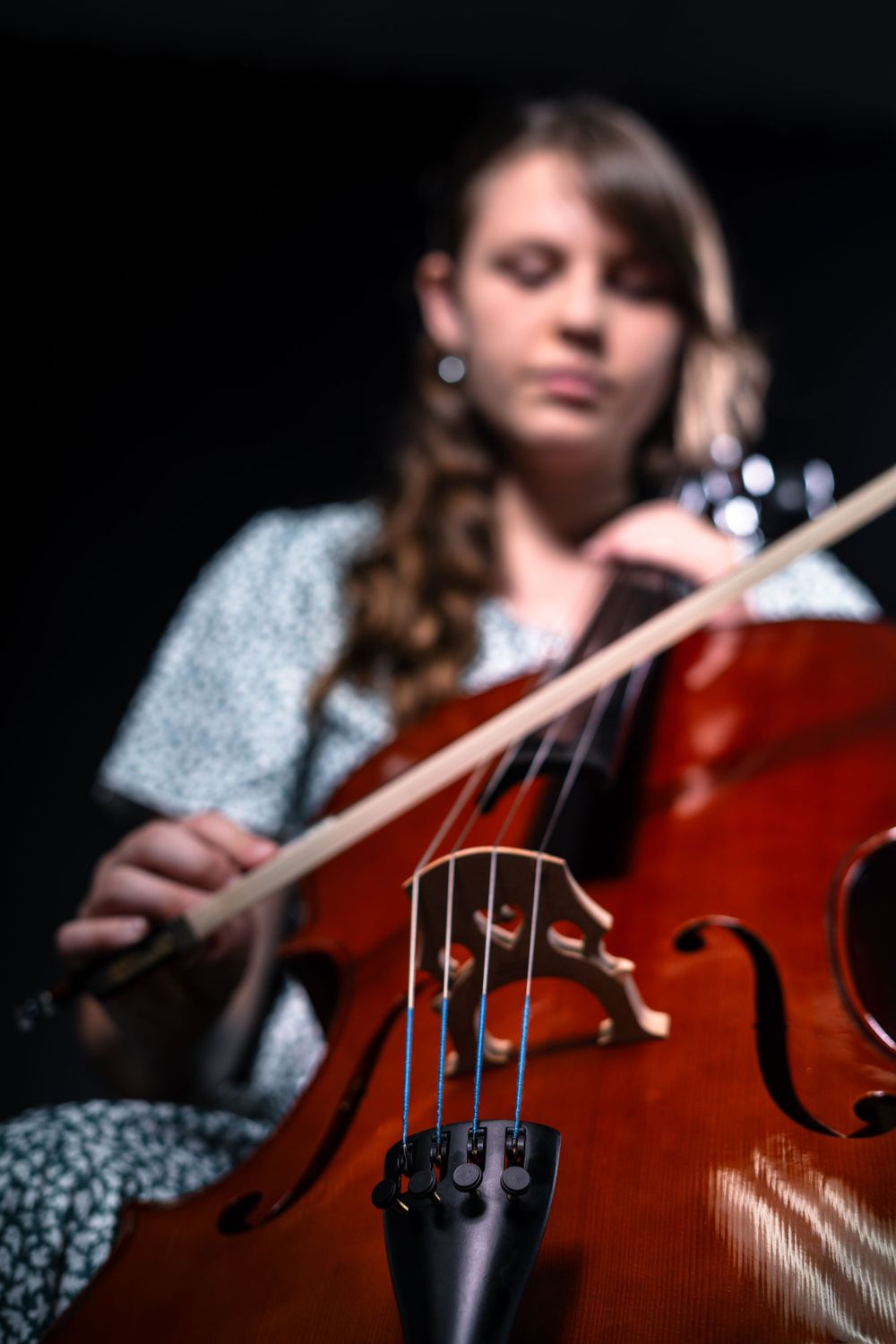 Detail shots focusing on cello strings and bridge during performance.
