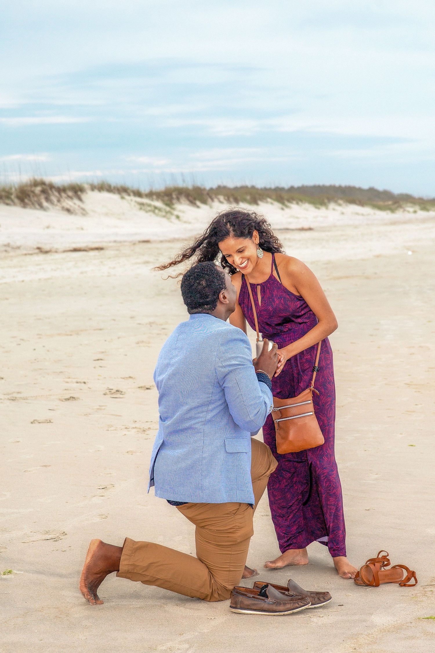 Surprise beach proposal with man kneeling and asking the big question at sunset, phot by Tasha Cannaday in Amherstburg Ontario.