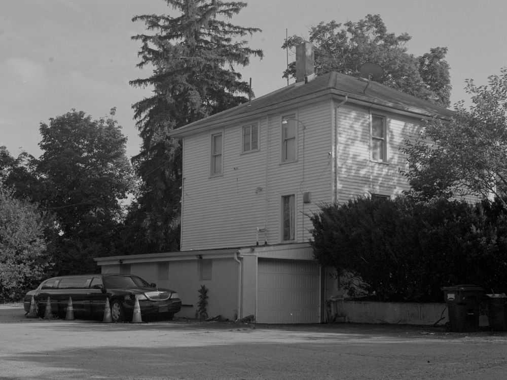 Multiple images of a white colonial style house with attached garage shown at different angles in black and white photography.