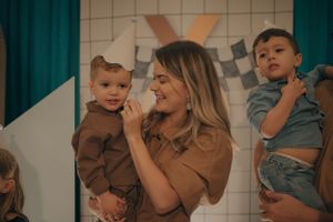 A tender moment at a celebration with family members against a tiled wall backdrop.