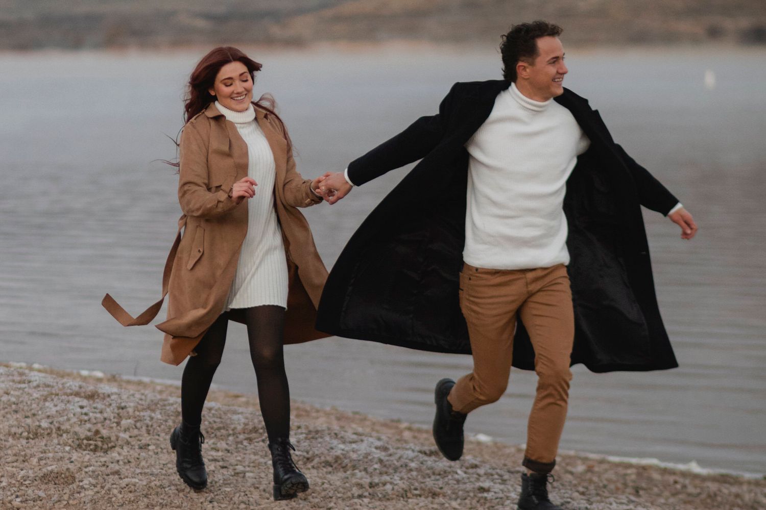 Couple runs along the shoreline during their portrait session.
